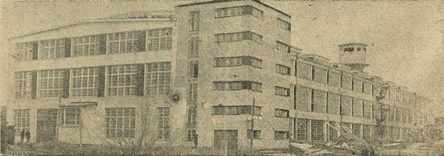 Schwarz-weißes Foto eines großen Gebäudes mit vielen Fenstern, beschriftet mit "New York Post Office", umgeben von Bäumen unter einem klaren Himmel.