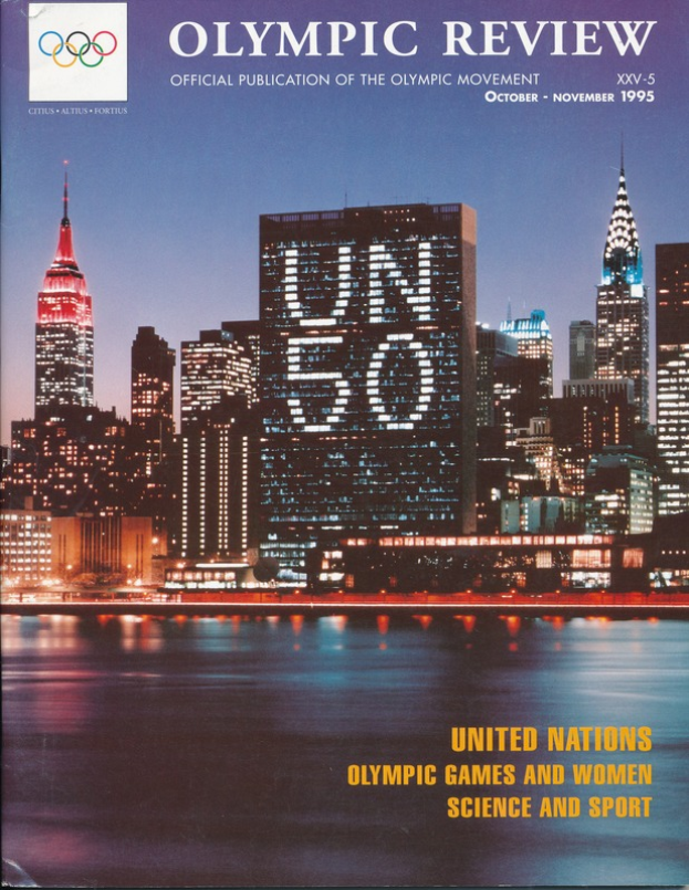 Ein Buch mit dem Titel "Olympic Review Official Publication of the Olympic Movement" liegt auf einer flachen Oberfläche und zeigt eine Stadtlandschaft mit Gebäuden, Lichtern und Wasser auf dem Cover, wobei auch der Text "United Nations Olympic Games and Women Science and Sport" zu sehen ist.