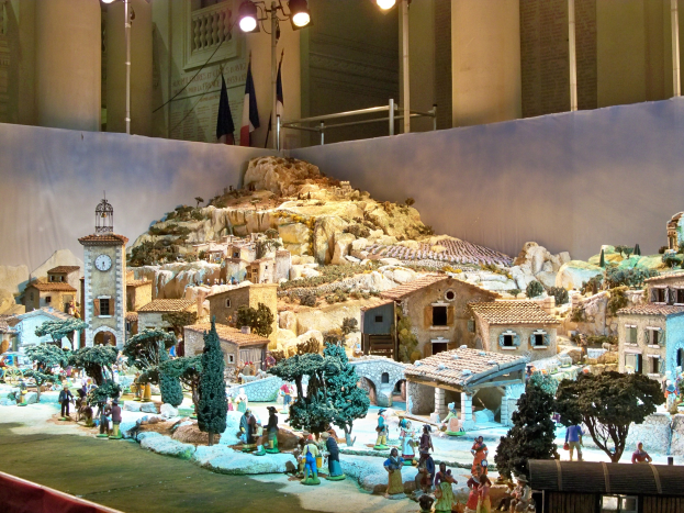 Ausstellung eines detaillierten Museumsmodells einer Krippe mit Figuren, Strukturen und beleuchteten Elementen.