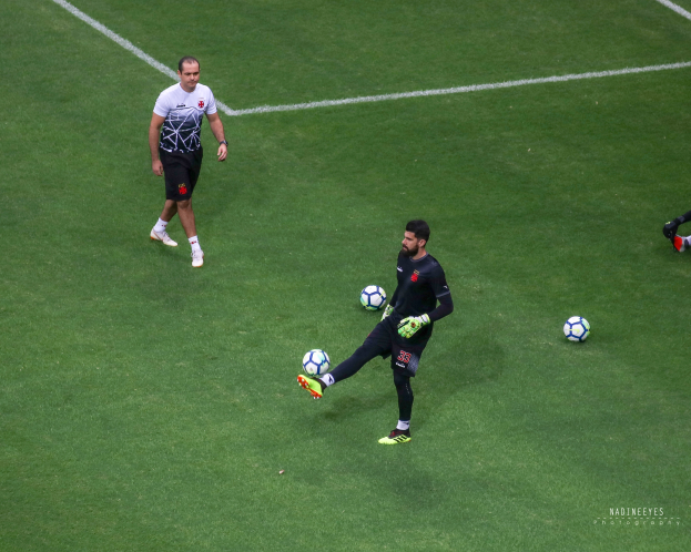 Ein Mann in einem Sportdress kickt einen Fußball auf einem saftig grünen Feld.