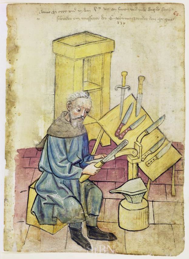 Ein älterer Mann sitzt auf einem Stuhl, hält in einer Hand ein Messer und in der anderen ein Blatt Papier mit Schrift darauf, mit mehreren Messern auf dem Tisch vor ihm.