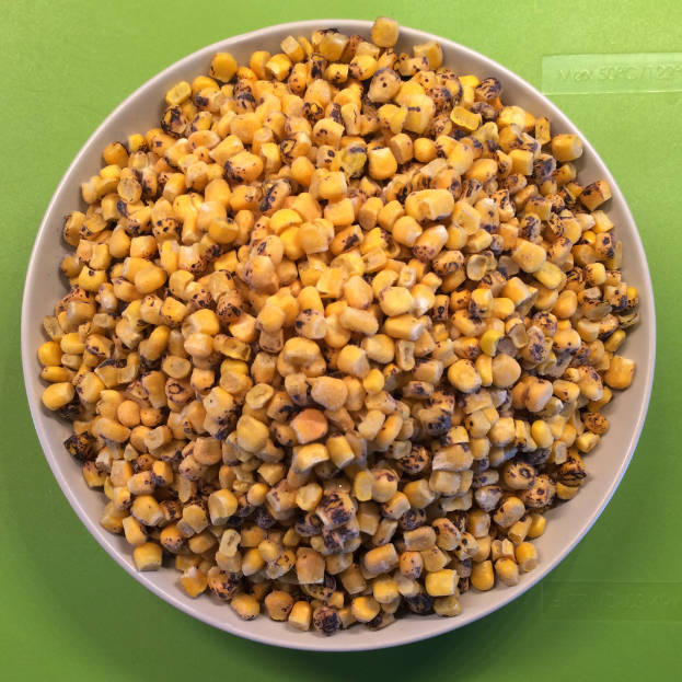 Ein weißer Napf mit Maiskörnern wird gegen einen grünen Hintergrund mit Text unten platziert.