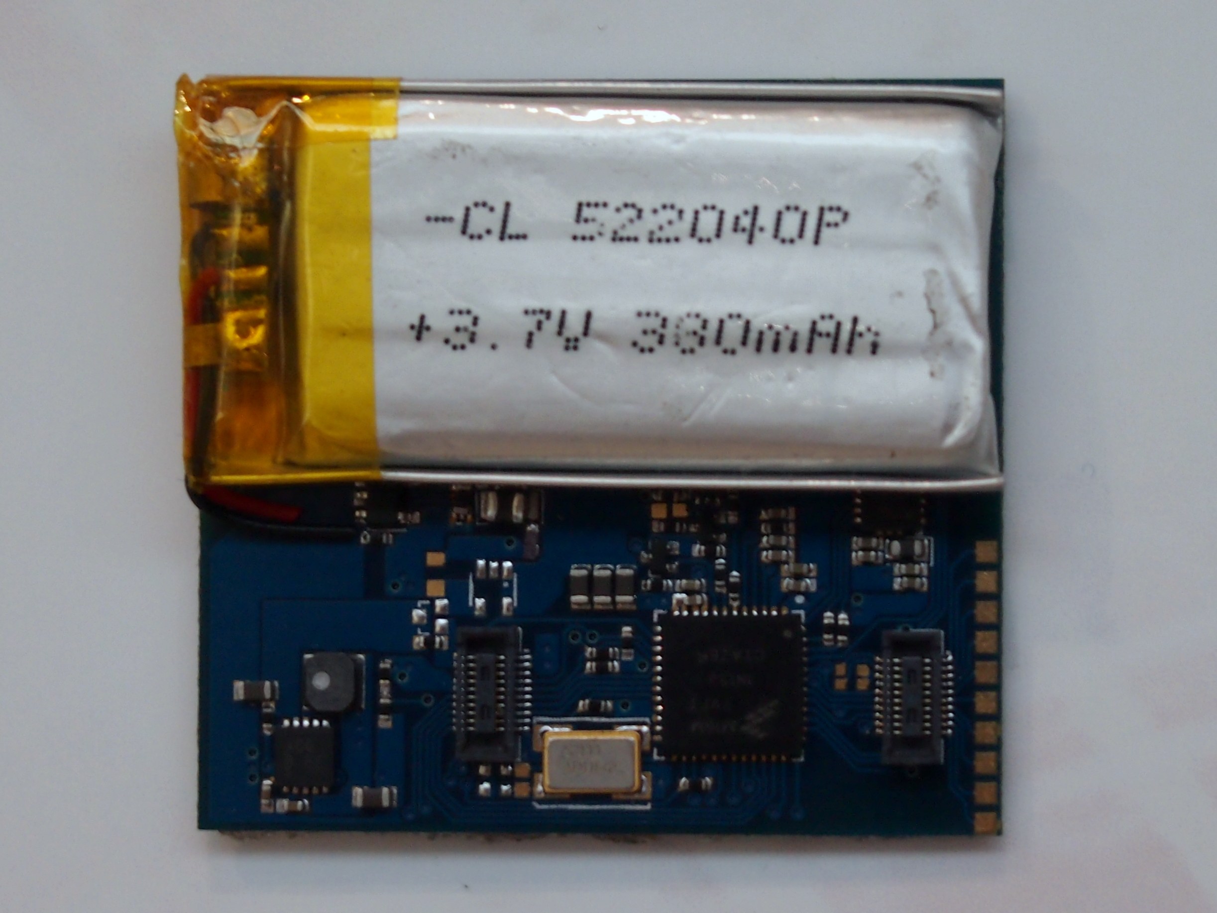 Nahaufnahme einer Smartphone-Batterie mit gedrucktem Text auf einer weißen Oberfläche über einer Leiterplatte.