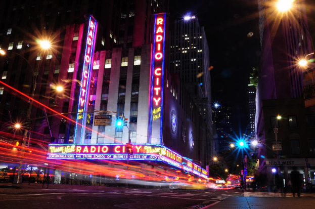 Gebäude und Straßenlaternen säumen eine Straße, auf der einige Menschen gehen.
