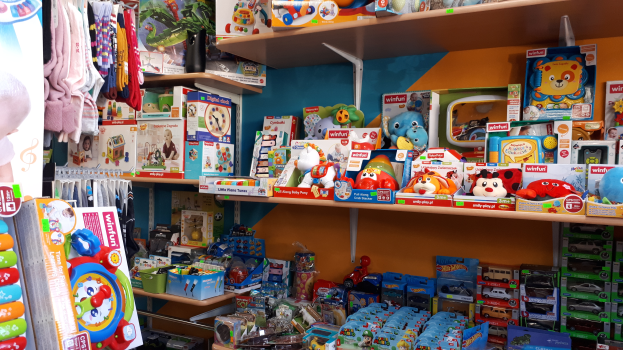 Ein Geschäft mit Regalen und Ständern voller Spielwaren, Kleidung und anderen Gegenständen.