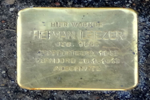 Ein rechteckiges Messingschild am Boden mit der Inschrift "Hier Wohnte Heiman Leezer."