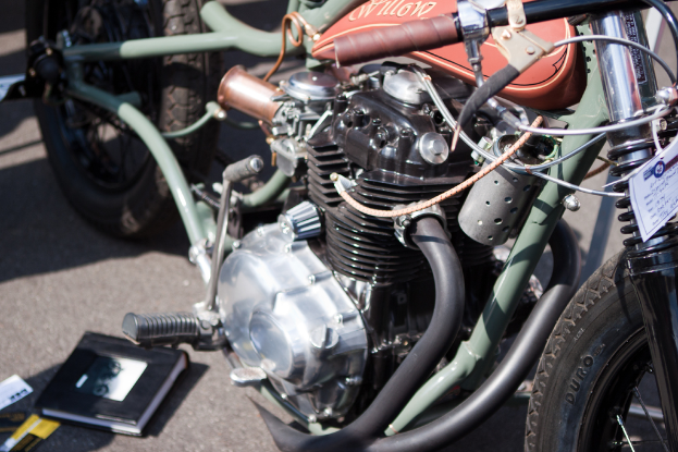 Mehrere Motorräder auf einem Parkplatz mit einem Buch auf einem der Sitze.