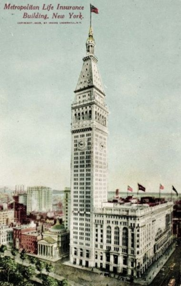 Schwarz-weiß-Postkarte des Metropolitan Life Insurance Building in New York City, die eine belebte Stadtkulisse mit mehreren Gebäuden, Bäumen und Fahrzeugen auf der Straße zeigt und den Text "Metropolitan Life Insurance" oben.