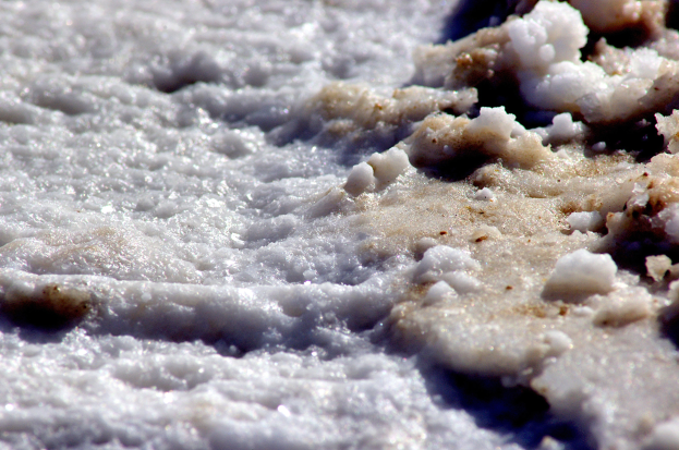 Nahaufnahme von weißem, flauschigem Schnee, der den Boden mit einer dicken Salzschicht bedeckt.