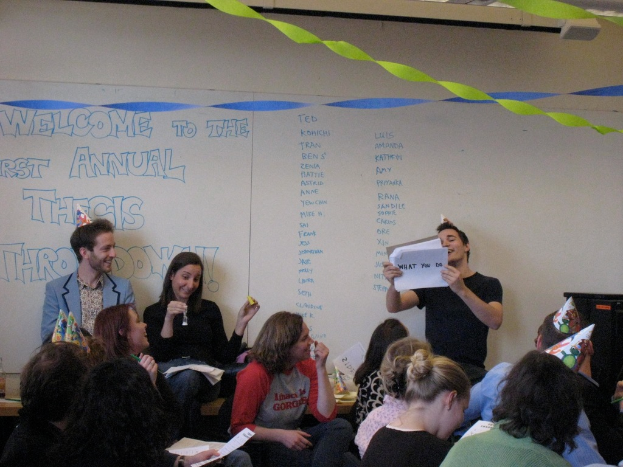 Eine Gruppe von Menschen feiert ihren ersten jährlichen Thesendown, mit Bändern auf dem Dach und einigen Individuen mit Kappen.