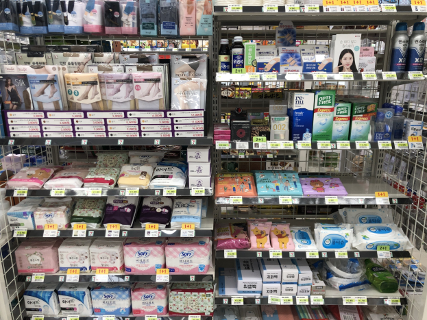 Ladeninneres mit verschiedenen Toilettenpapierarten auf Regalen mit sichtbaren Preisschildern.