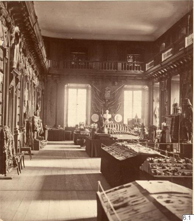 Schwarzes und weißes Foto eines Raums im Museum of Fine Arts, London, voller Tische, Stühle, Skulpturen an den Wänden, Fenstern, Vorhängen und Geländern.