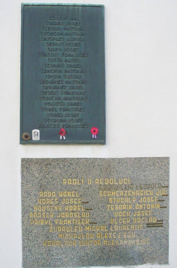 Zwei Gedenktafeln an der Seite eines Gebäudes angebracht, jeweils mit Text beschriftet, der likely den Gefallenen des Krieges ehrt.