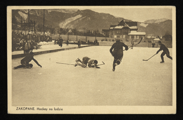 Altes Schwarz-Weiß-Foto von Menschen, die Hockey auf einem Eisplatz spielen, umgeben von Gebäuden, Bäumen, Pfählen und Bergen im Hintergrund, und Text unten.