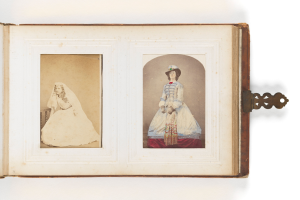 Ein altes Buch mit einer Illustration einer fröhlichen Braut in einem weißen Kleid mit Schleier und Tiara und einem Bräutigam in einem Anzug, der einen Blumenstrauß hält und ihre Hochzeit feiert.