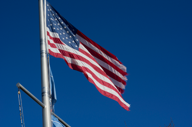 Eine US-Flagge ist auf der linken Seite des Bildes positioniert.