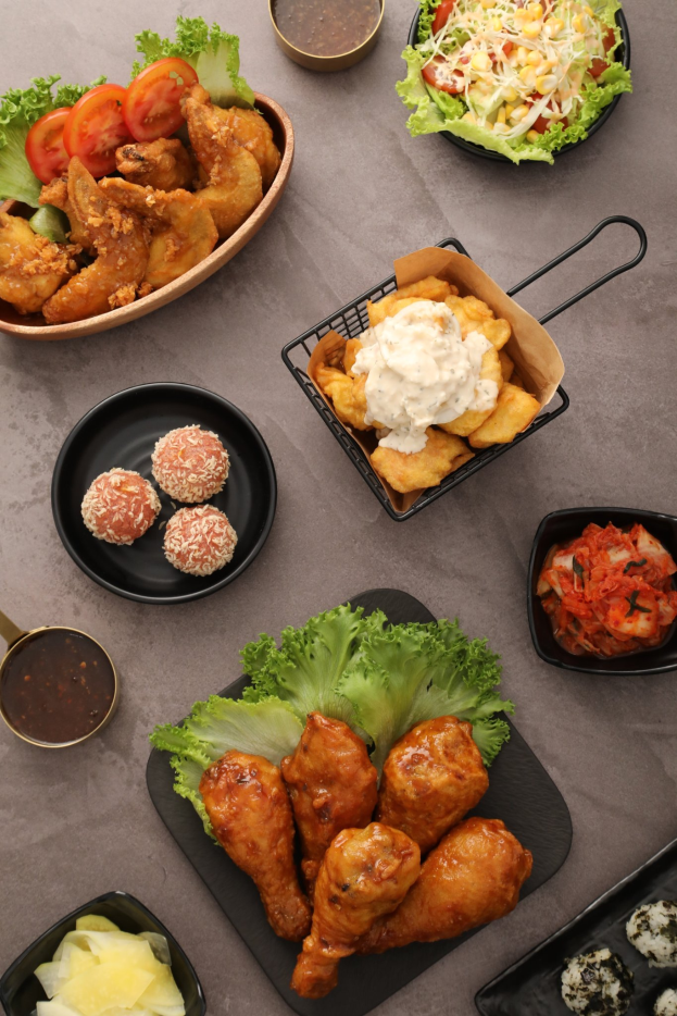 Ein Tisch zeigt Teller mit Essen, Schöpfen mit Dip-Saucen und verschiedene andere Essensartikel, die ordentlich angeordnet sind und damit auf einen Lieferservice eines Restaurants hinweisen.