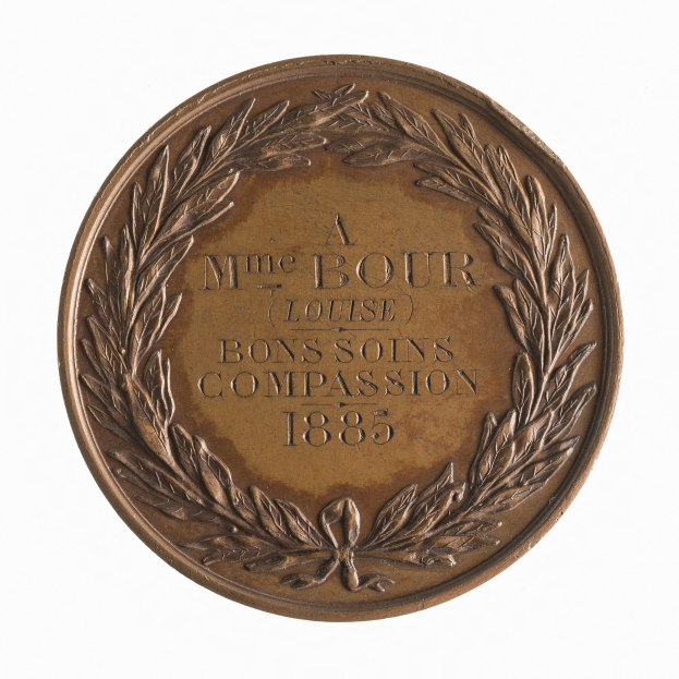 Bronze-Medaille mit Lorbeerkranz und der Aufschrift "Bons Soins Compassion" vor weißem Hintergrund.