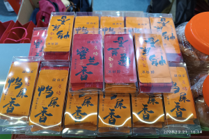 Ein Tisch mit verschiedenen verpackten Lebensmitteln und Gegenständen während eines chinesischen Neujahrsfestes, mit einer Person im Hintergrund.