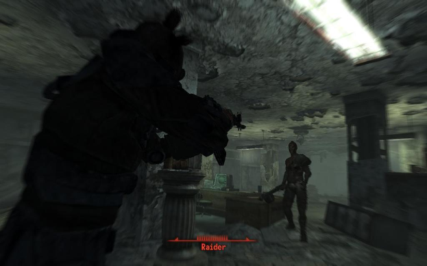 Das Innere eines Gebäudes mit Skulpturen, einer Leuchte und einem gerahmten Objekt an der Wand.