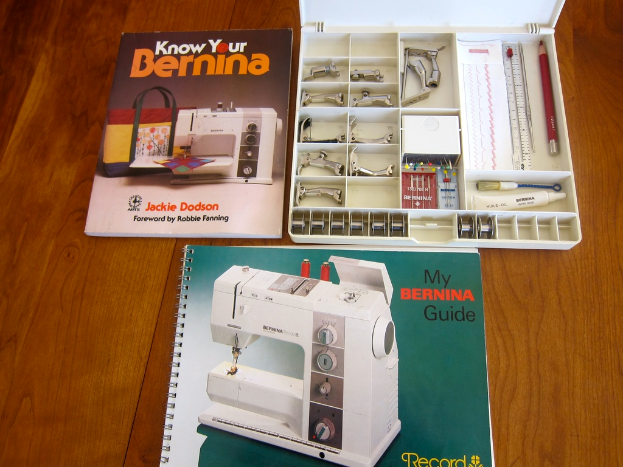 Zwei Bücher und eine offene Werkzeugkiste mit Werkzeugen darin sind auf einem Tisch platziert.