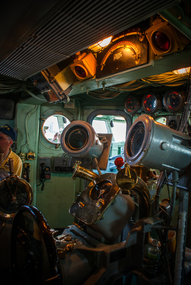 Das Innere eines Zuges mit Sitzen und verschiedenen Gegenständen, mit einer Person in einem gelben T-Shirt auf der linken Seite.