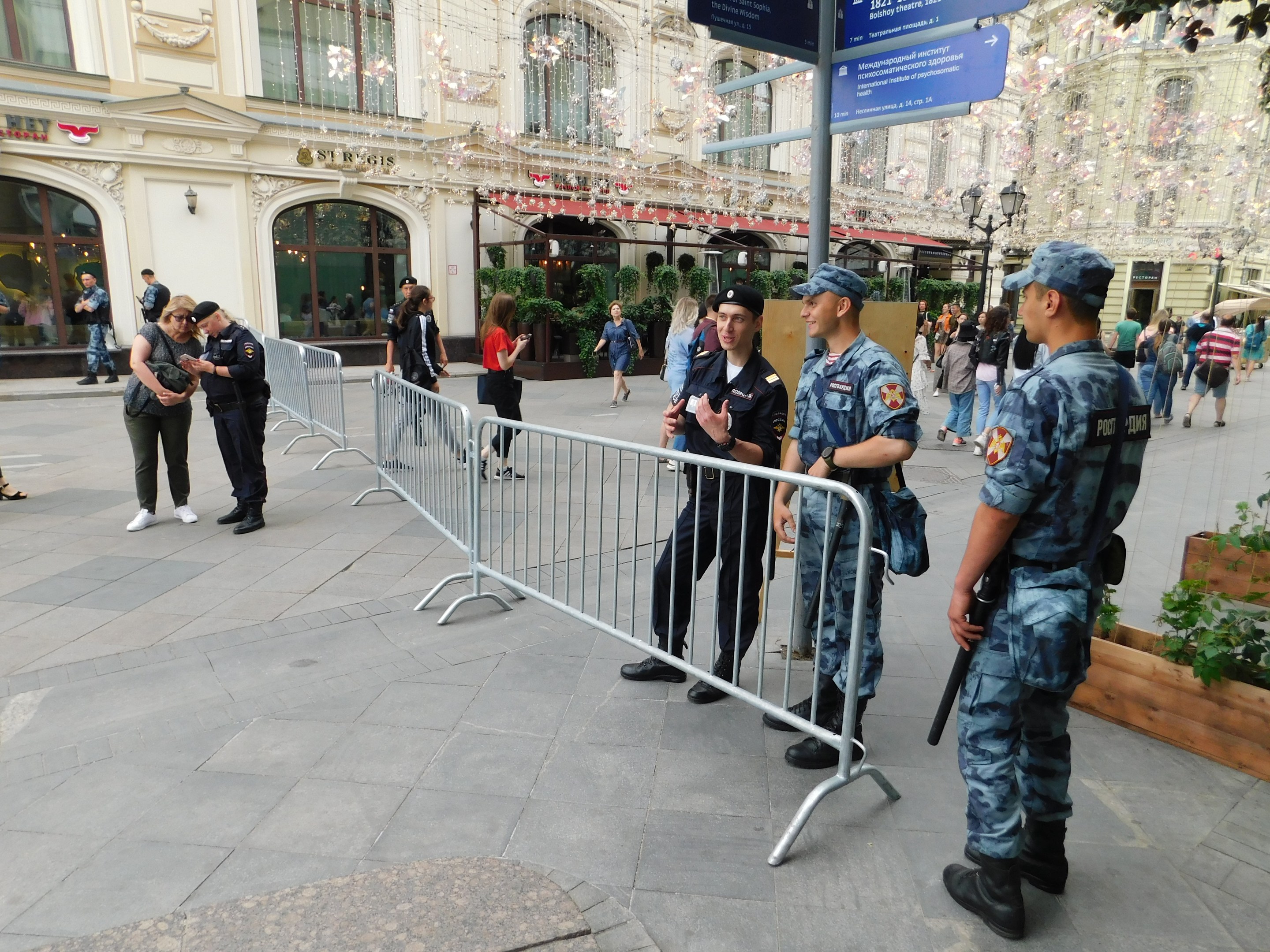 Polizeibeamte in Uniform stehen hinter Barrieren und blicken auf eine Menge, einige halten Waffen, während sie eine Anti-Terror-Operation in Wien, Österreich durchführen.