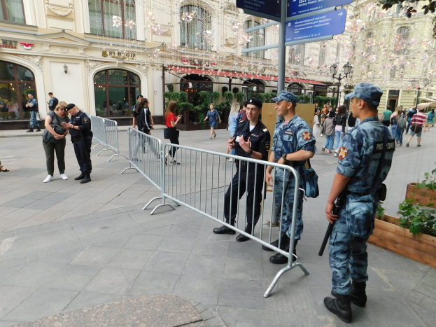 Polizeibeamte in Uniform stehen hinter Barrieren und blicken auf eine Menge, einige halten Waffen, während sie eine Anti-Terror-Operation in Wien, Österreich durchführen.