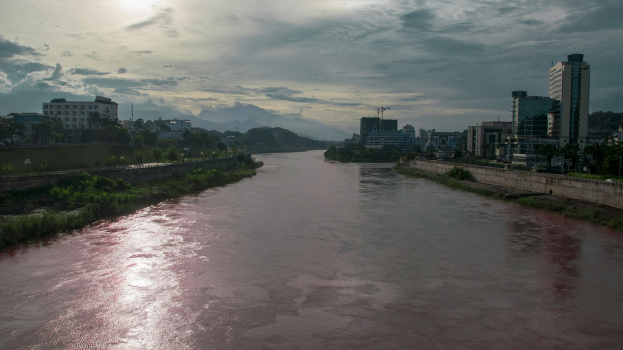 Ein breiter Fluss mit zahlreichen Gebäuden und Anlagen an seinen Ufern.