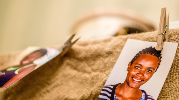 Auf einem Tisch liegt eine Klammer, ein passportgroßes Foto und ein Stoffstück auf der rechten Seite, mit einem unscharfen Hintergrund und linker Seite.